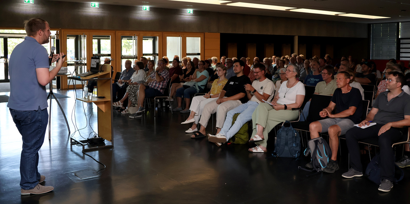 Das Bild zeigt Dr. Michael Haas und das Publikum.
